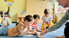 Kinder liegen auf dem Boden und spielen Kartenspiel